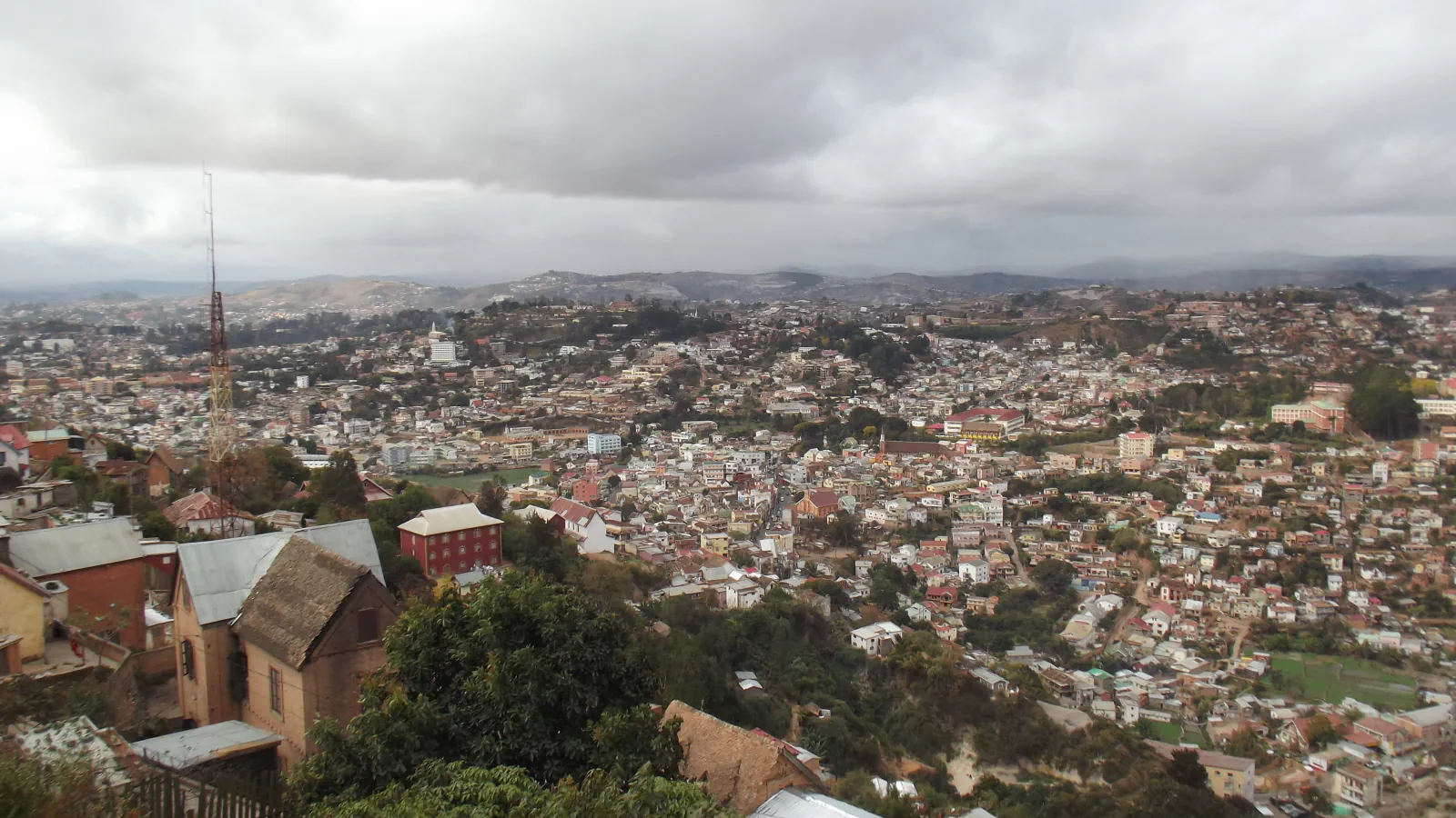 Hillside houses and a broad view across Antananarivo beneath low clouds