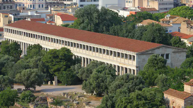 Reconstructed Stoa of Attalos: a long two-storey colonnaded building with a red-tiled roof above the excavated Agora.