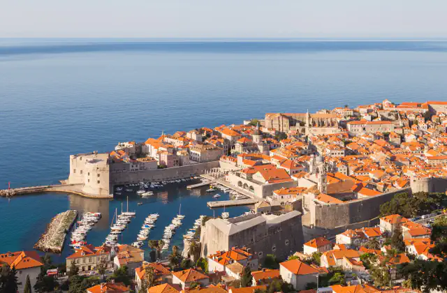 Dubrovnik’s old harbour, city walls and red-roofed houses beside the Adriatic Sea