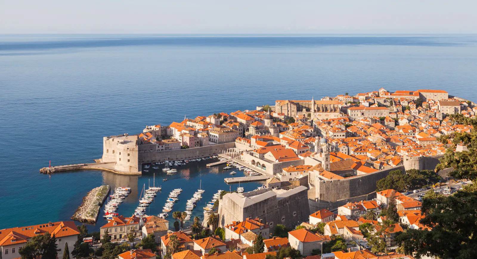 Dubrovnik’s old harbour, city walls and red-roofed houses beside the Adriatic Sea
