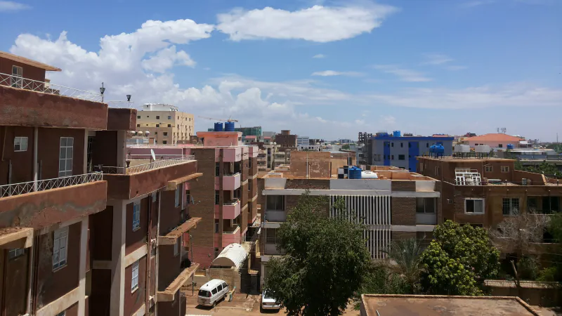 Rooftops and apartment buildings in Khartoum viewed from above.