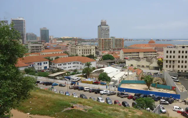 Luanda’s Baixa rooftops and office towers seen from higher ground, with the bay beyond