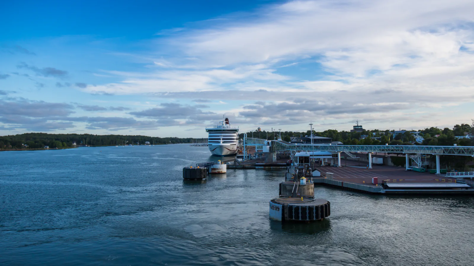 Mariehamn harbour: a large ship beside a pier and terminal on calm water.