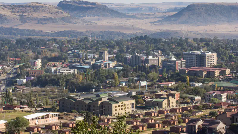 Rooftops, trees and distant hills in a broad view of Maseru