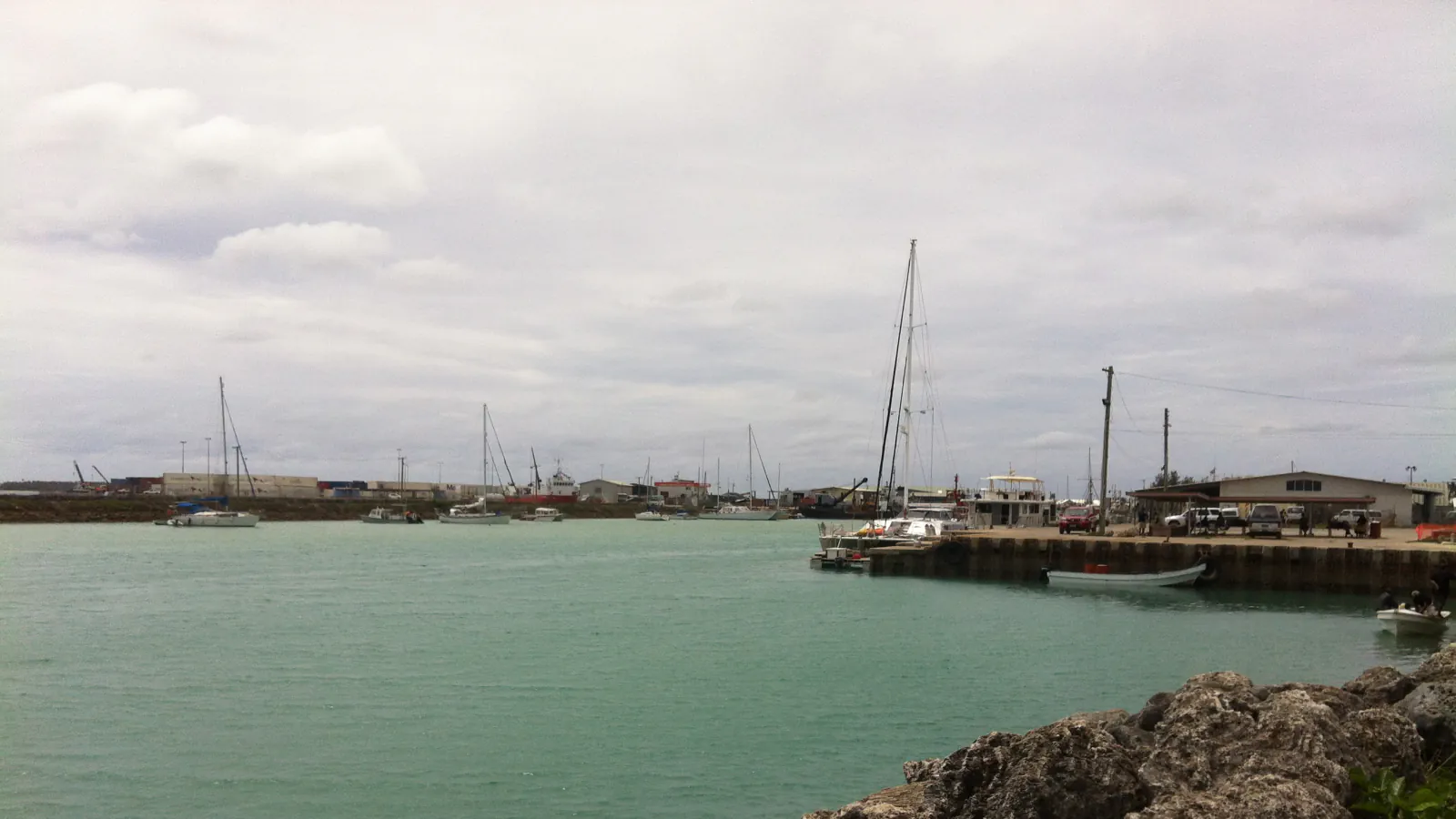 A harbour pier, moored boats and sailboat masts at Nuku’alofa.
