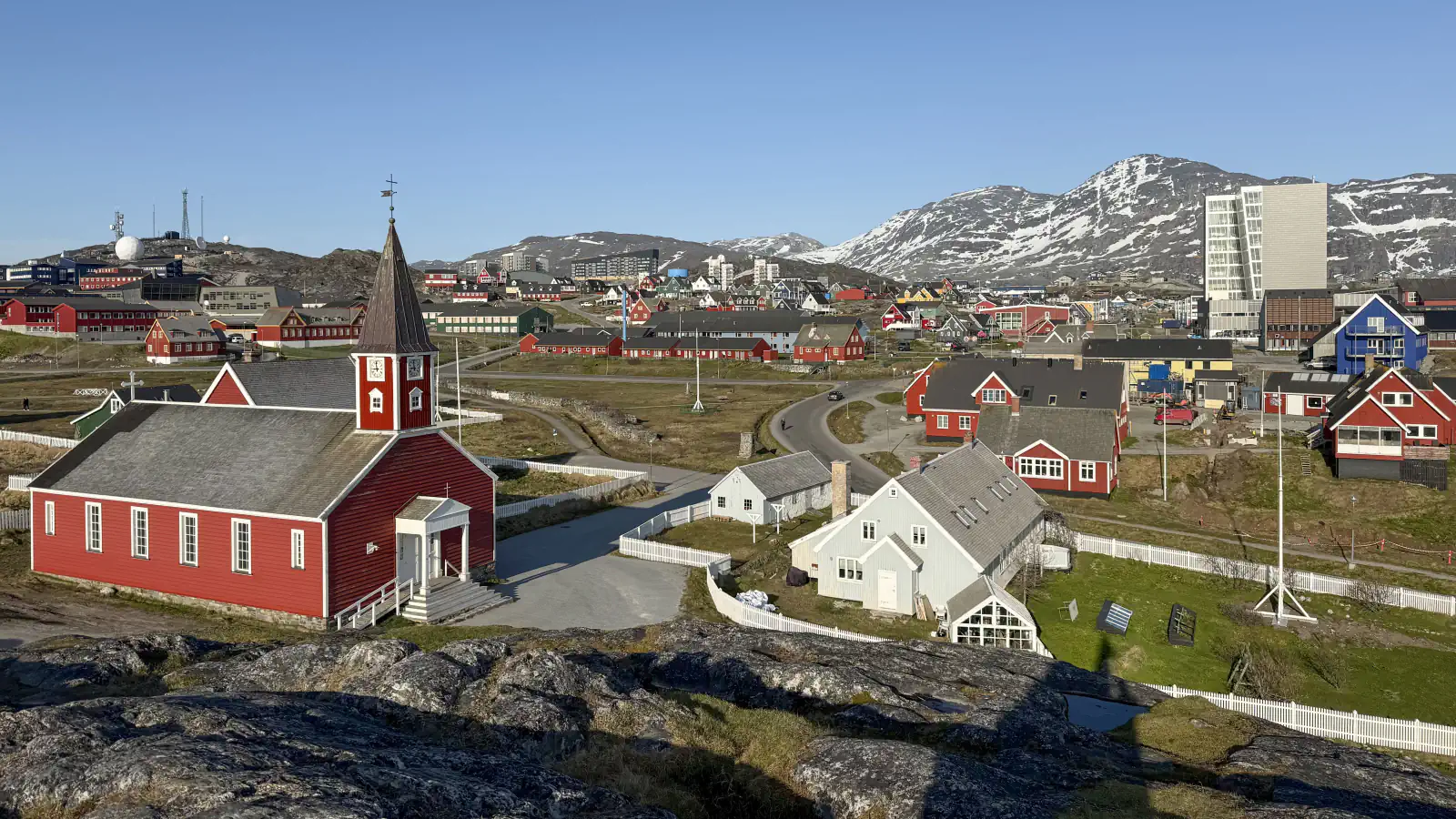 Red church, houses and snow-streaked hills in Nuuk