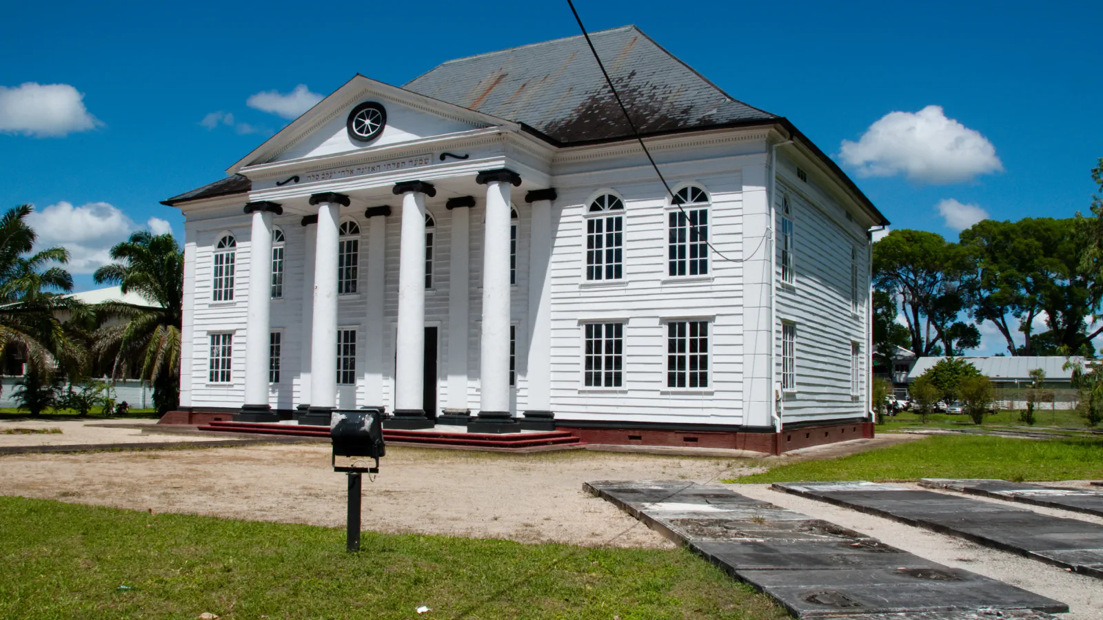 White timber Neve Shalom synagogue in Paramaribo with columned porch and lawn