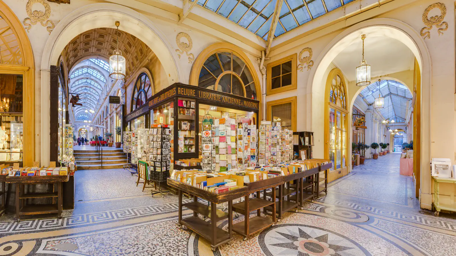 Bookstalls, mosaic floor and glazed roof inside Galerie Vivienne in Paris
