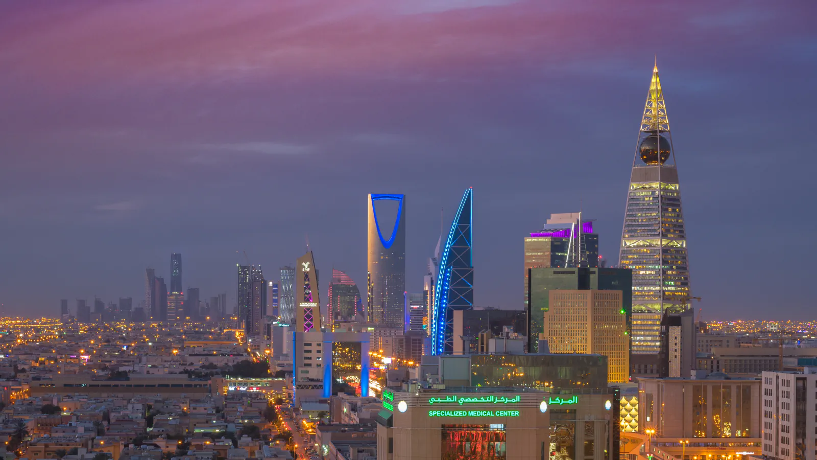 Riyadh skyline with illuminated high-rise buildings.