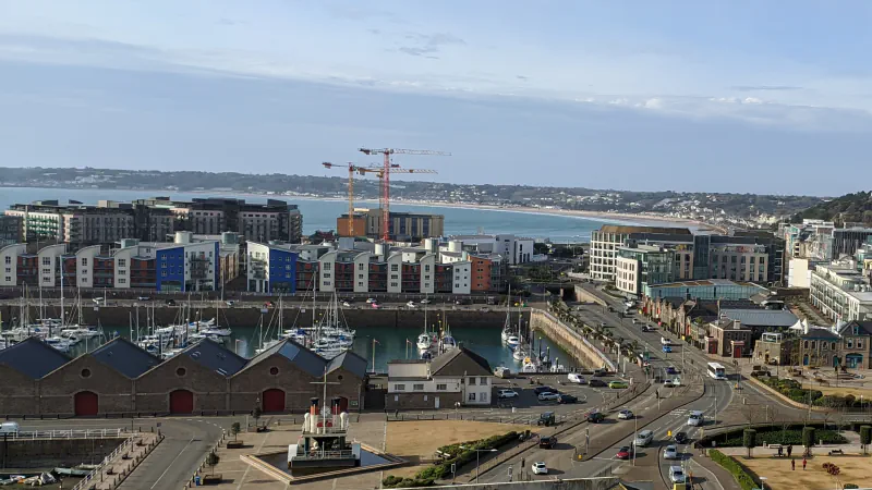 Pristanišče mesta Saint Helier s čolni, obalnimi stavbami in zalivom