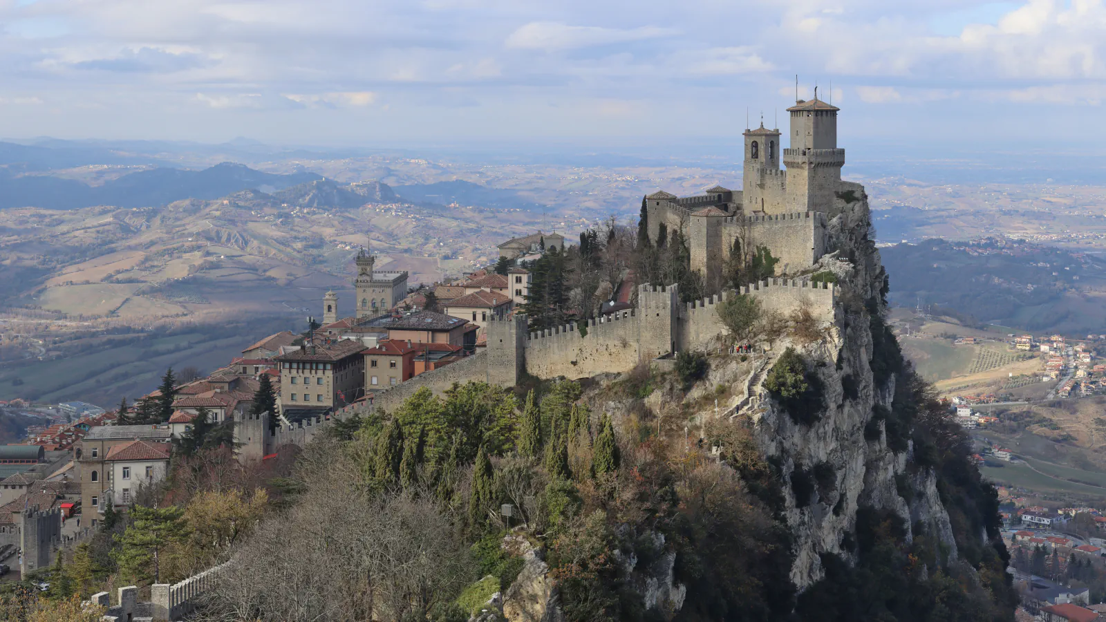 Guaita fortress rising above the rooftops and green slopes of San Marino