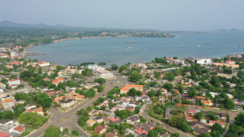 Pogled iz zraka na ulice, drevesa in stavbe mesta São Tomé ob zalivu Ana Chaves