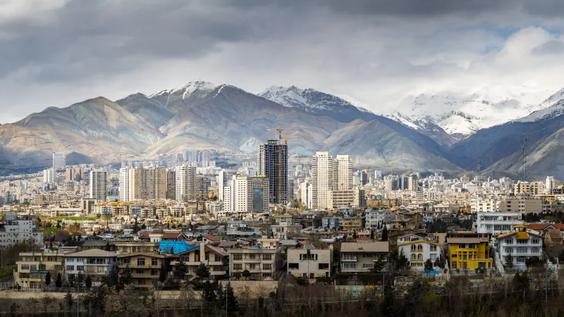 Panorama gosto pozidanega Teherana pod zasneženim pogorjem Alborz