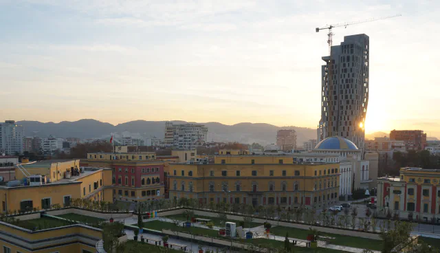Tirana buildings and a tall tower at sunset, seen from the Clock Tower